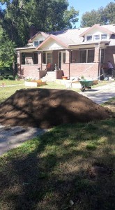 The 5 tons of dirt arrived. You can see the comparison with the house in the background and the beds waiting.